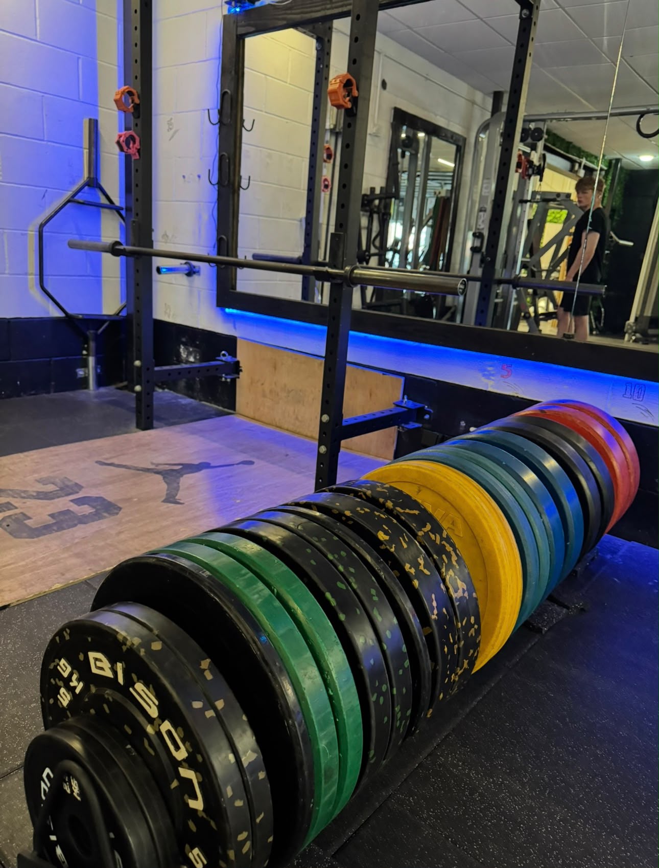 Colourful bumper plates by the lifting platform